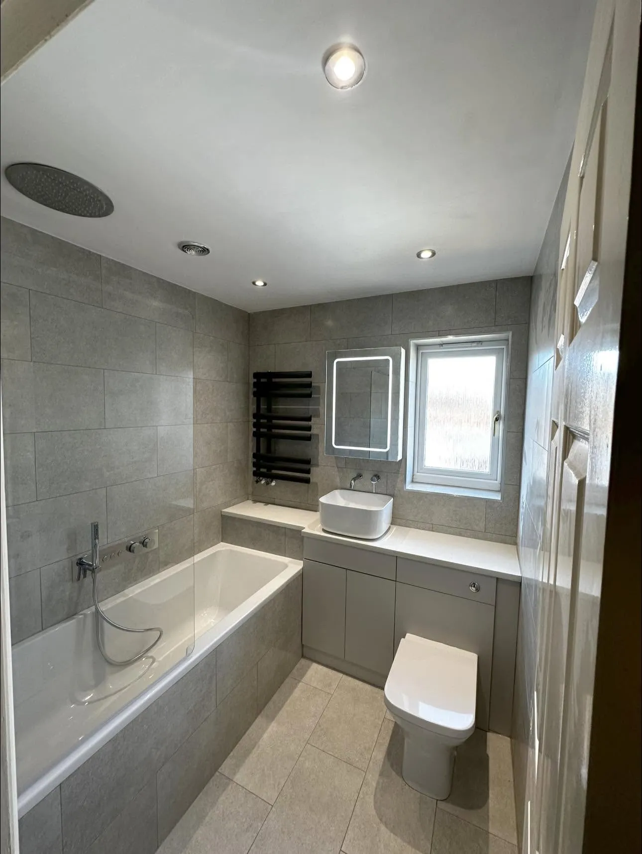 Full view of the grey bathroom from the doorway
