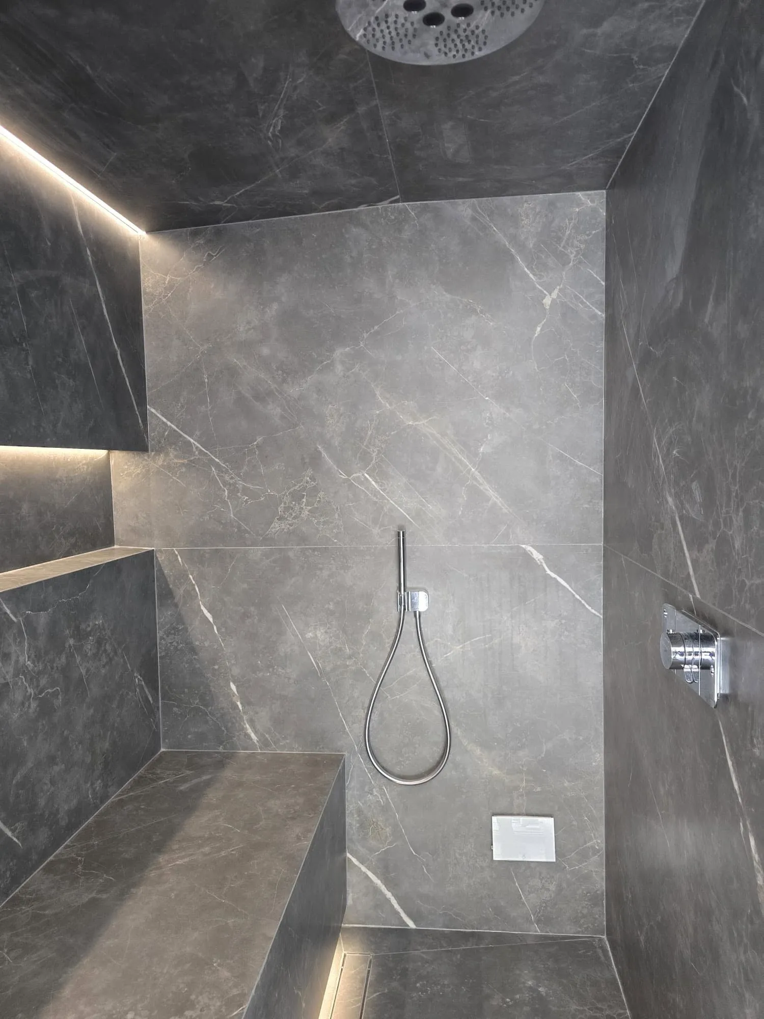 Steam room interior with rainhead, tiled bench and LED reveals