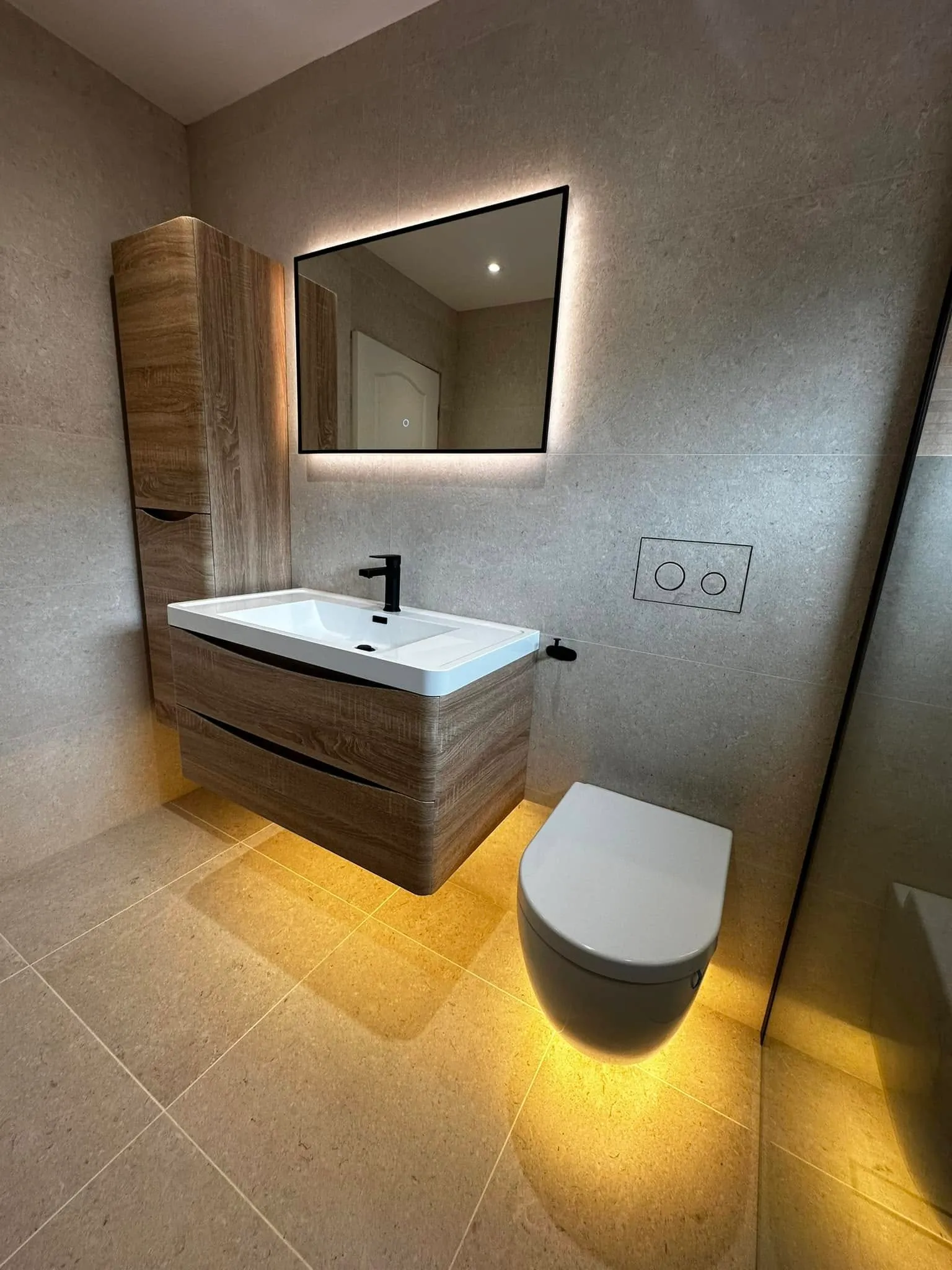 Floating oak vanity and wall-hung WC with halo lighting