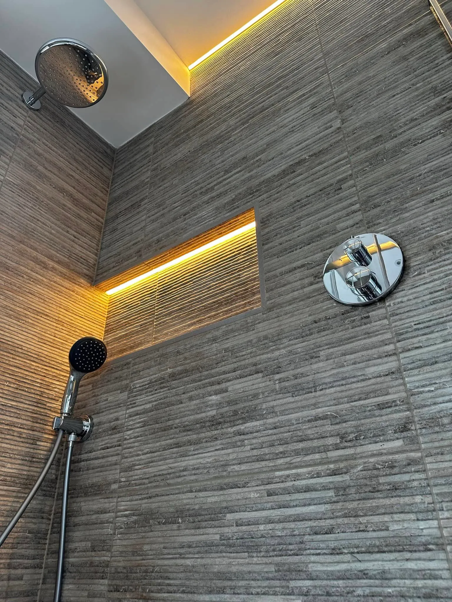 Looking up at the rainhead, lit niche and thermostatic valve
