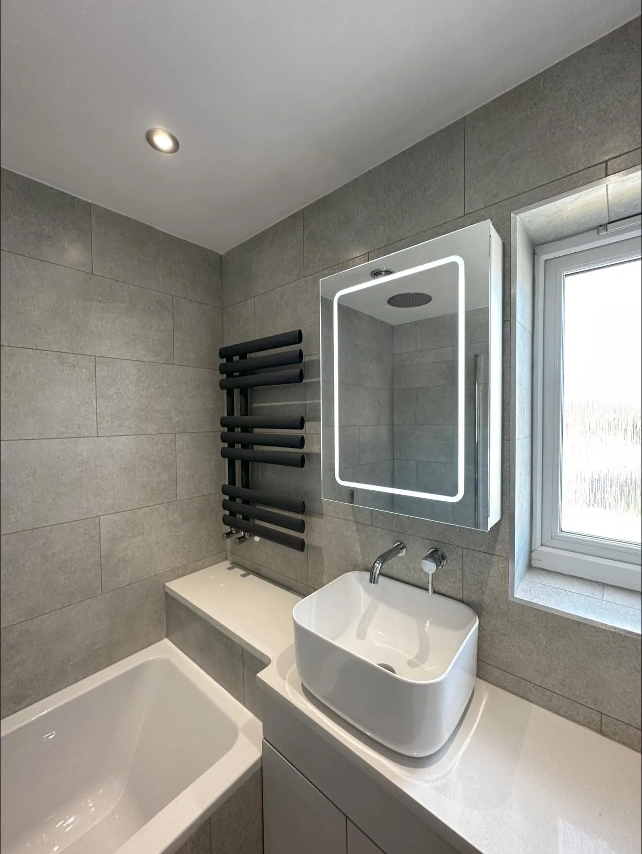 Countertop basin with wall-mounted chrome mixer and mirror cabinet