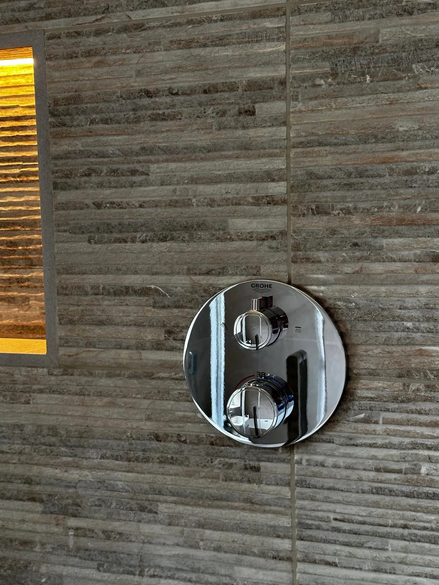 Thermostatic valve set against split-face ledgestone