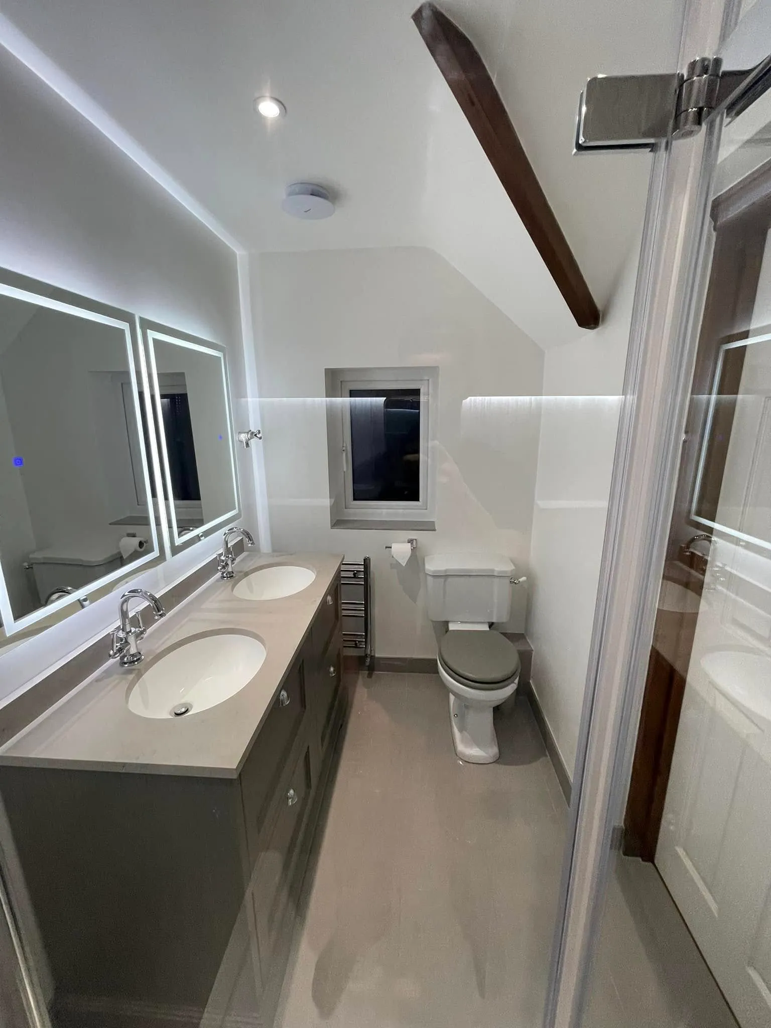 Loft en-suite with grey shaker double vanity, quartz worktop, twin basins and LED backlit mirrors