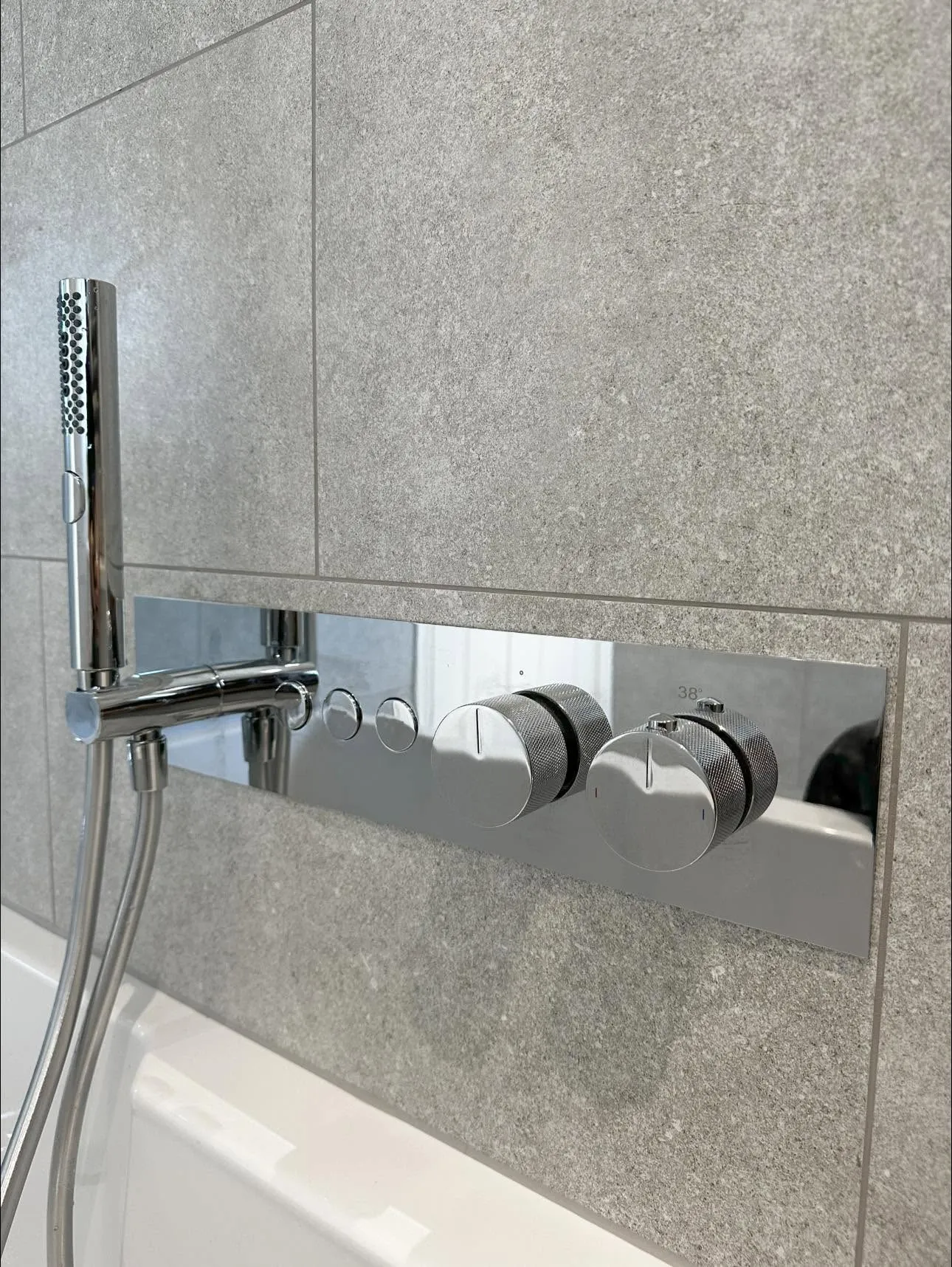 Chrome thermostatic shower panel and handset detail