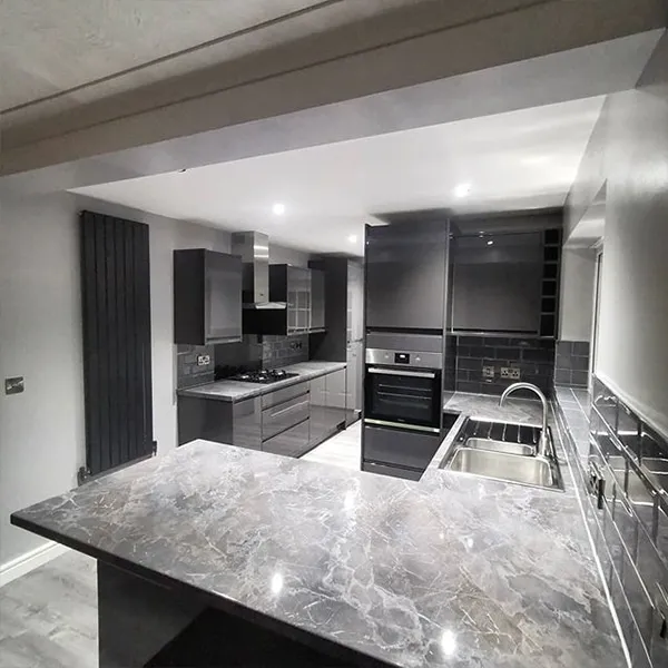 Grey gloss handleless kitchen with marble-effect peninsula worktop and anthracite designer radiator
