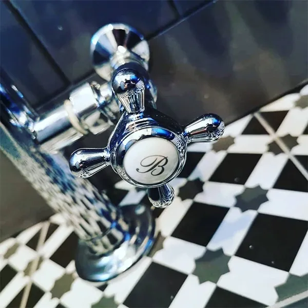 Traditional chrome crosshead pillar tap over star-pattern Victorian floor tiles