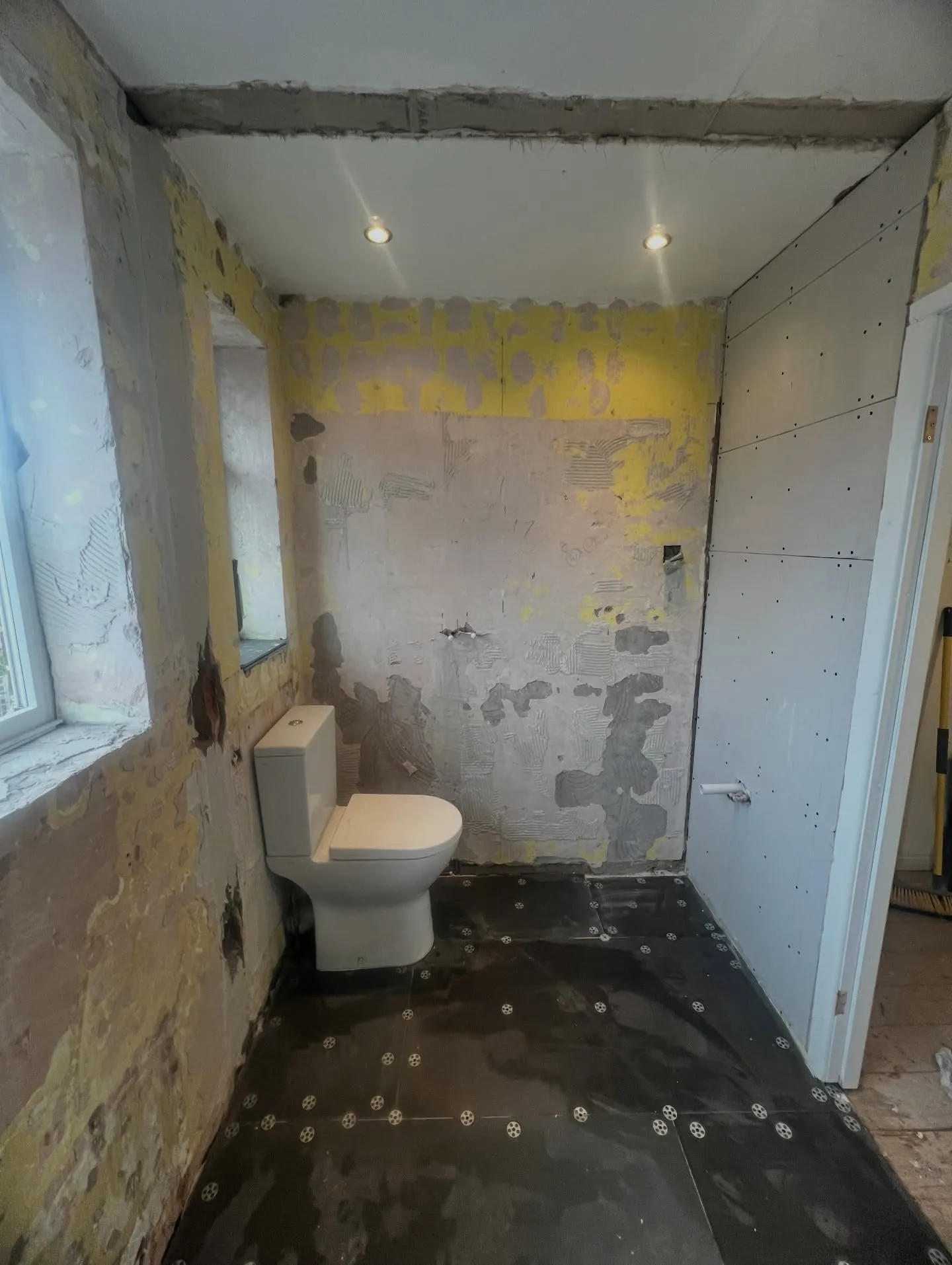 The same bathroom before renovation — stripped back to bare plaster walls